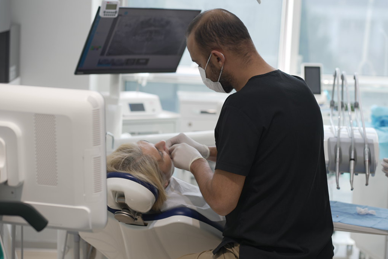 Diş hekimi Alper Boz implant muayenesi yaparken – modern diş kliniği